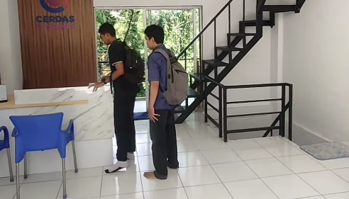 Dua orang siswa sedang berbicara dengan pengajar